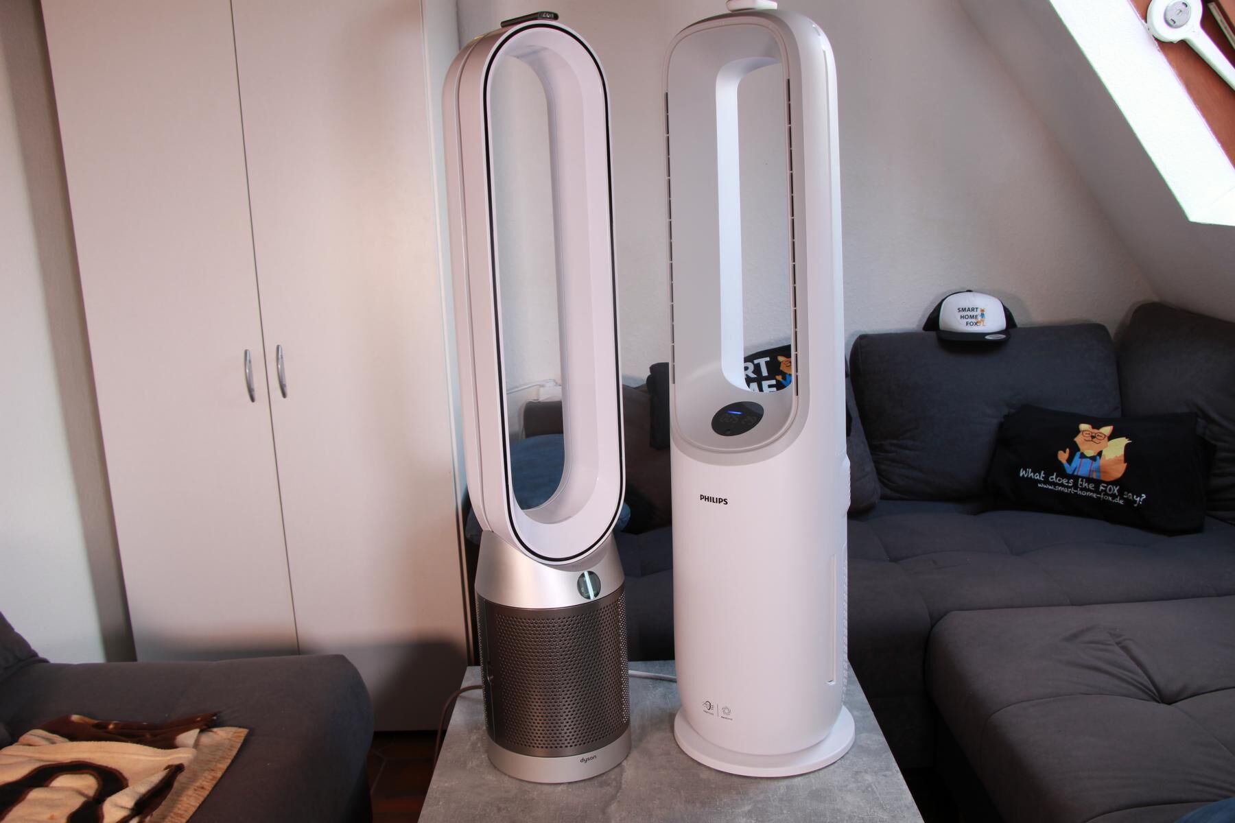 Philips Air Performer Series 7000 (AMF765/10) стоит рядом с Dyson Purifier Cool Autoreact TP7A на журнальном столике во время тестирования и сравнения.